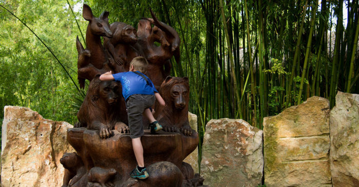 enfant qui grimpe sur une sculpture